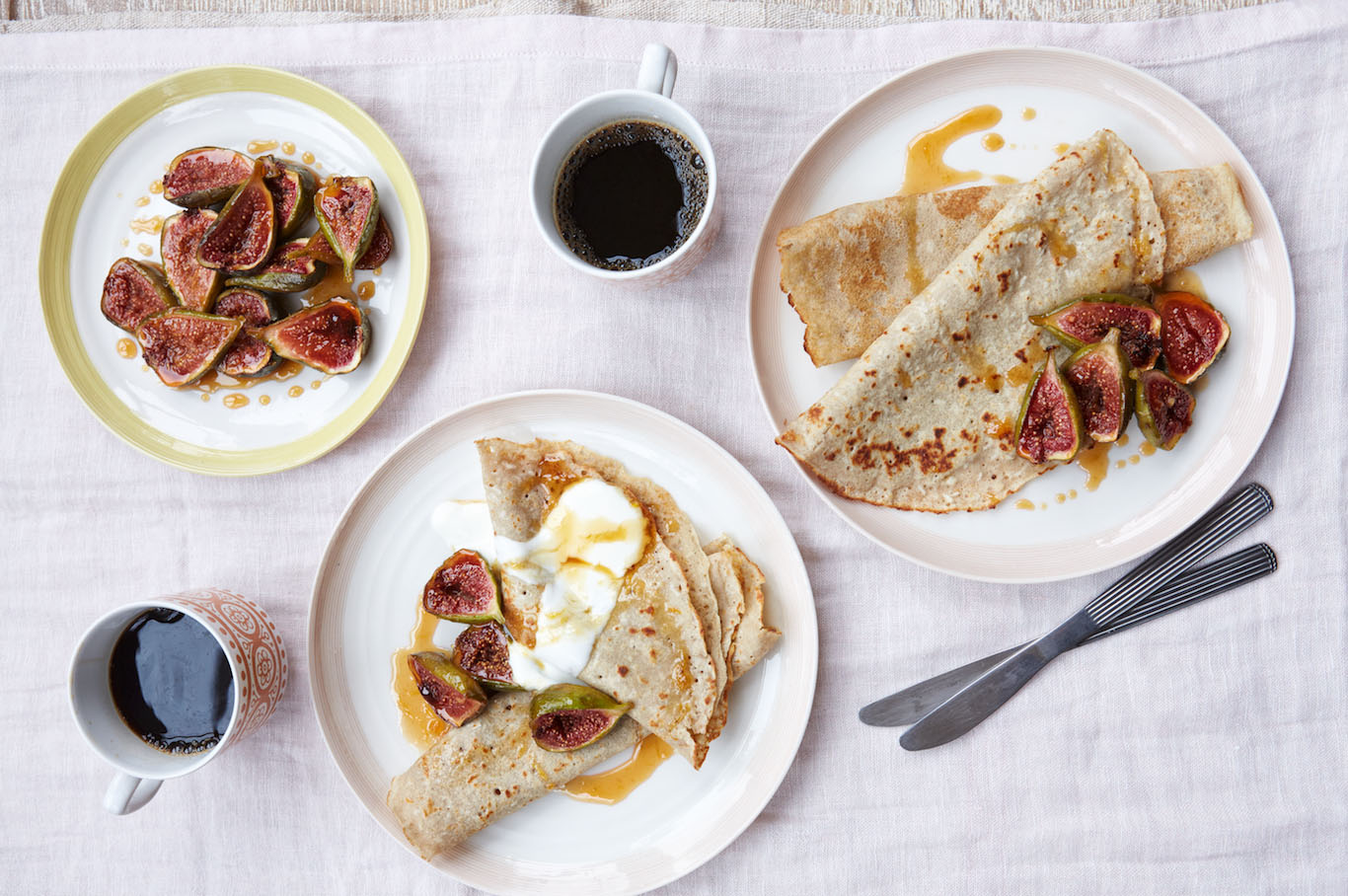 Close-up of finished buckwheat crepes garnished with warm roasted figs and coconut flakes.