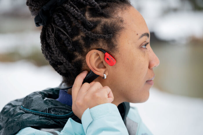 Waterproof bone conduction headphones submerged in water during an ingress protection test.