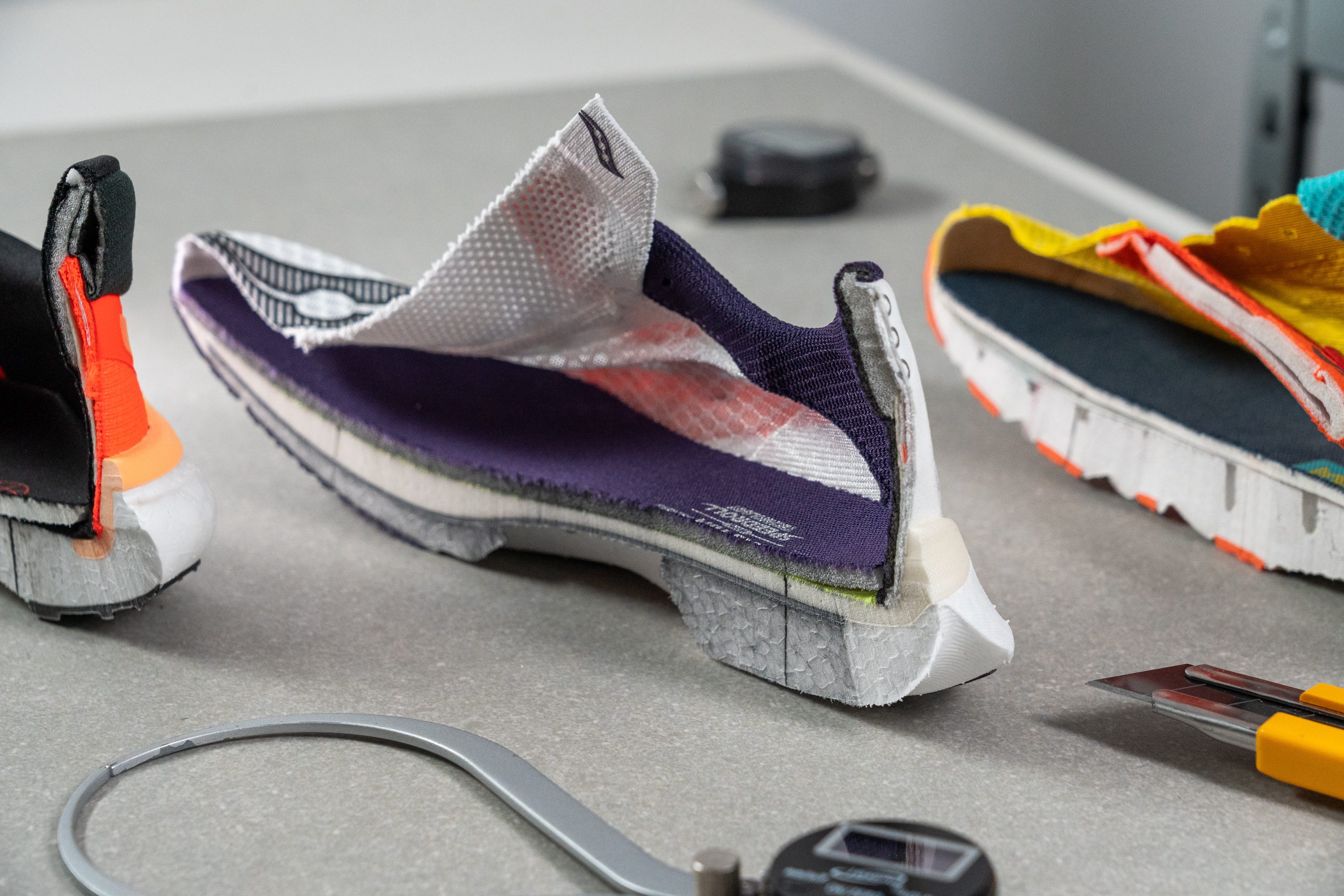 Professional experts in a laboratory setting conducting tests on various running shoe models.