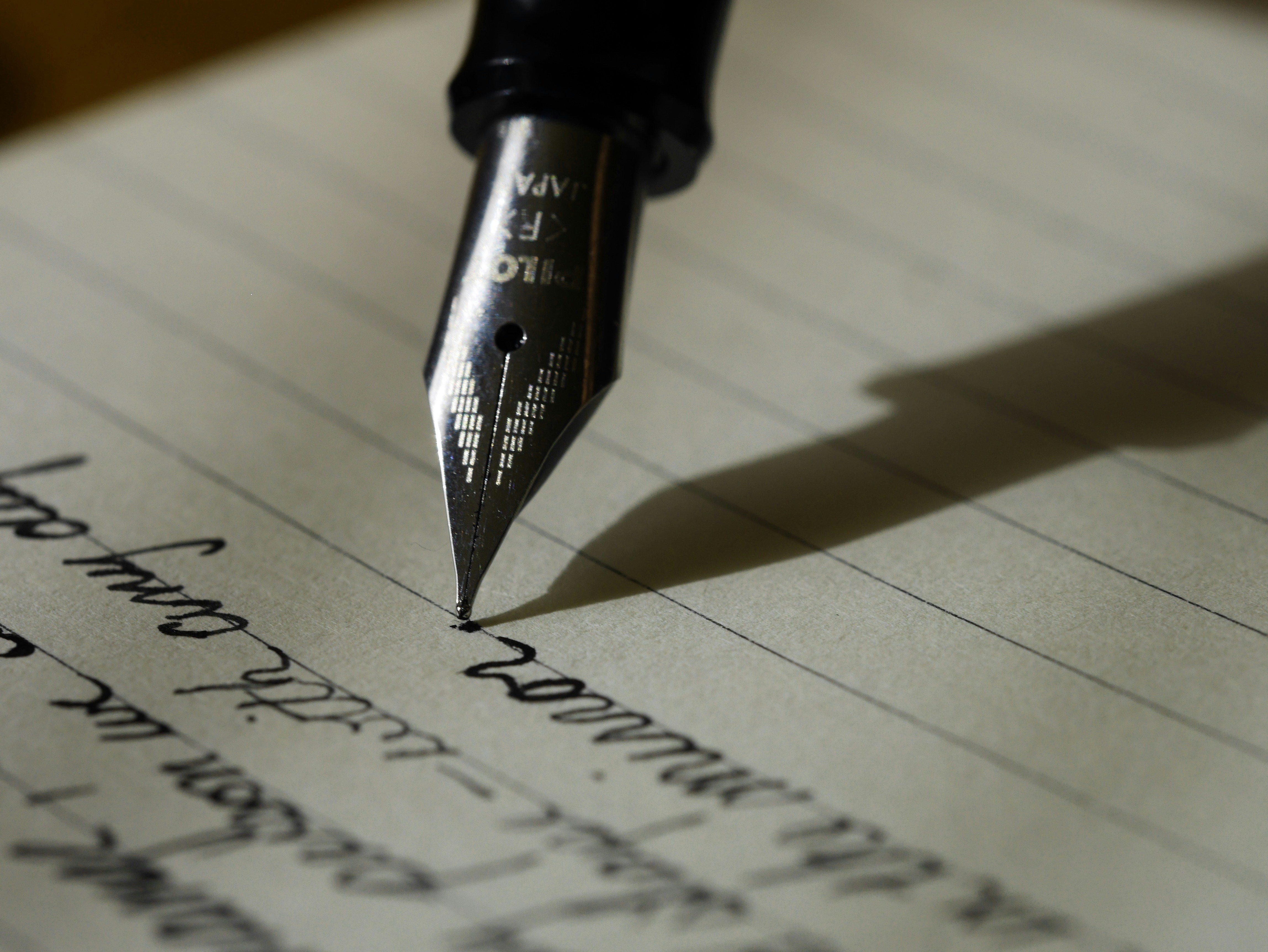 Handwriting entries into a paper sleep diary to track sleep and wake times.
