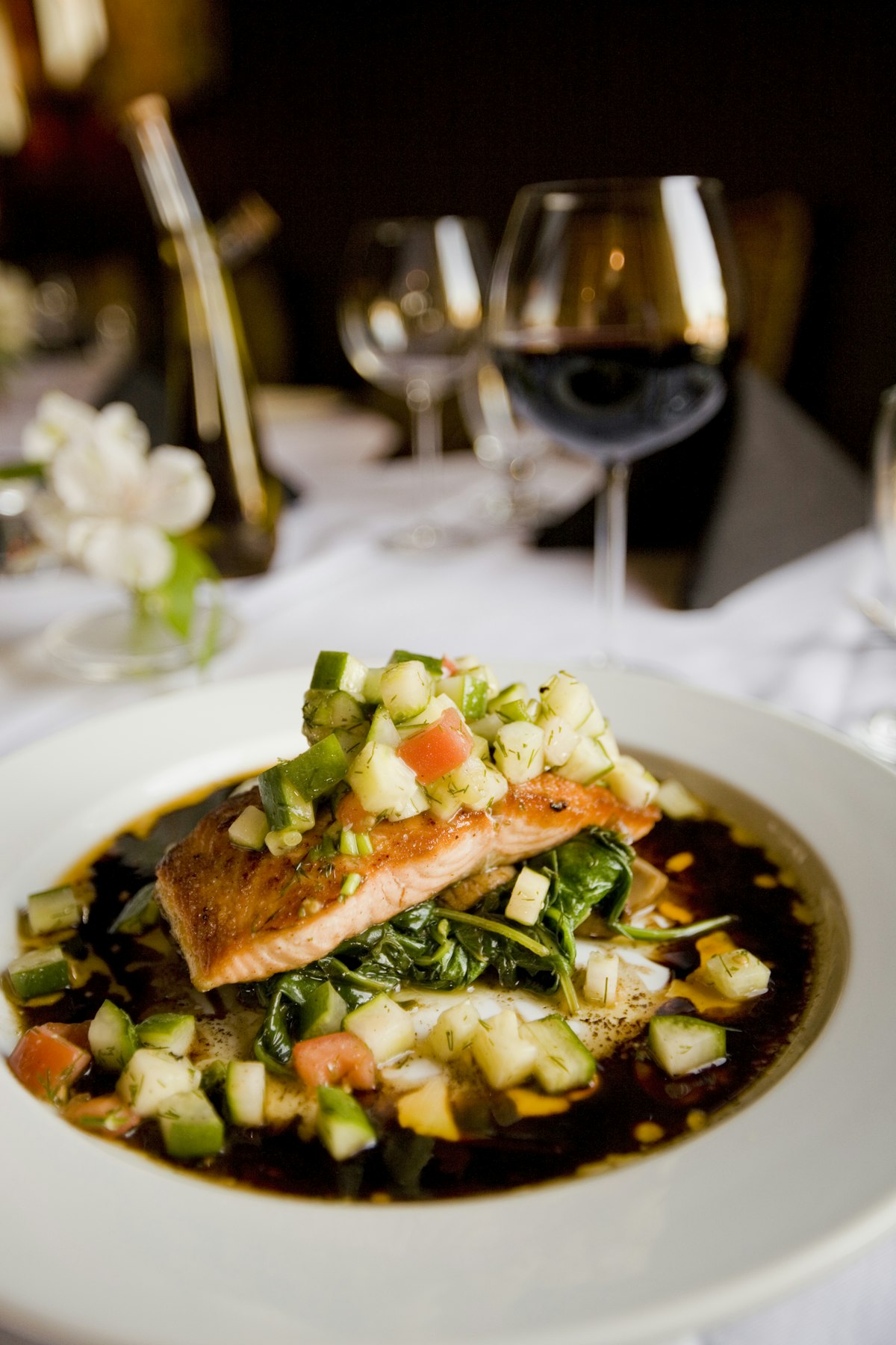 A close-up of a grilled salmon fillet served with quinoa and steamed broccoli.
